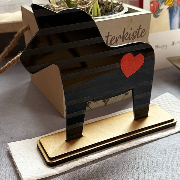 Dala Pferd aus Acryl auf Holzsockel mit eingesetztem Kunststoff-Herz aus PLA.